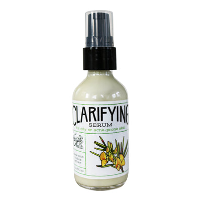 Clarifying face serum in a clear glass bottle with black top and white label