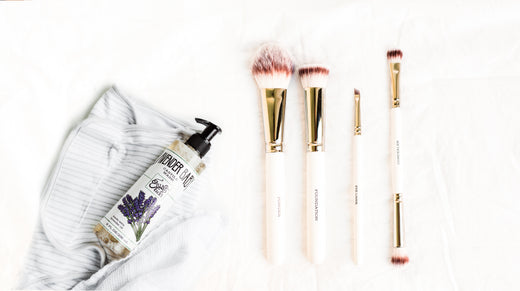 white makeup brushes against white cloth + lavender castile wash on baby blanket