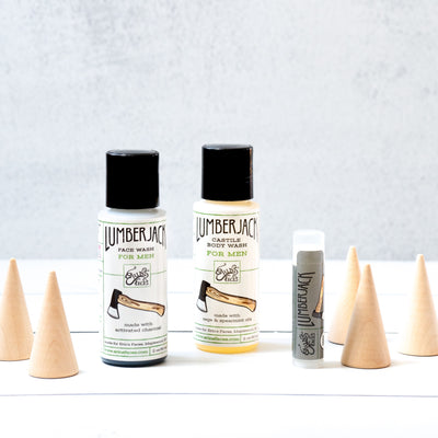 lumberjack face wash and castile wash mini bottles with lip balm surrounded by wooden trees