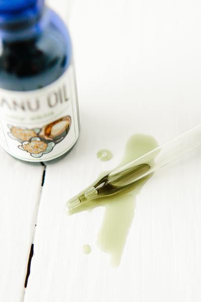 Blue bottle of Tamanu Oil with white label.